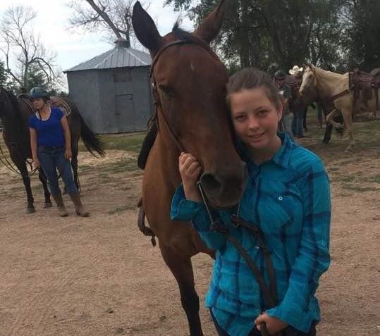 Kelly standing next to a horse