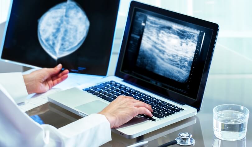 Radiation technician examining a mammography image